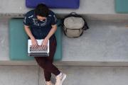 Overhead view of student on steps studying on laptop