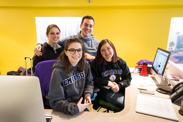 Undergraduate students smiling at the visitor's desk