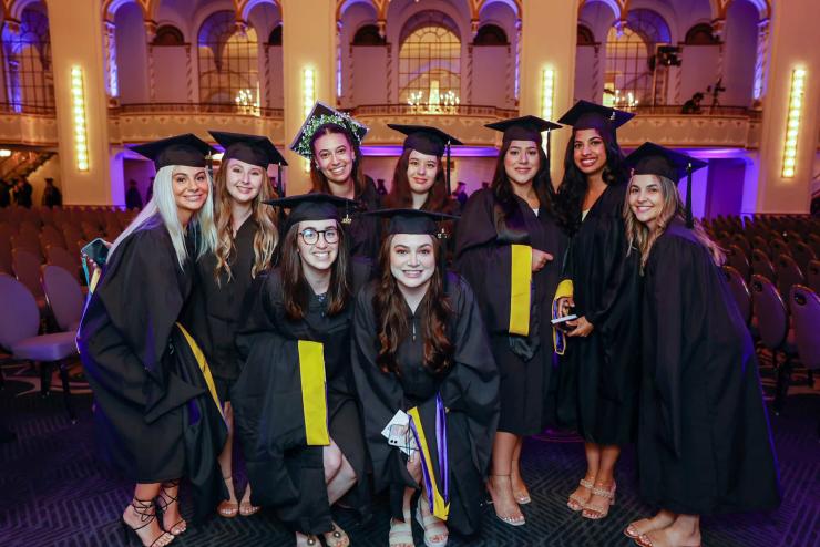 A group of students posing for a photo in caps and gowns