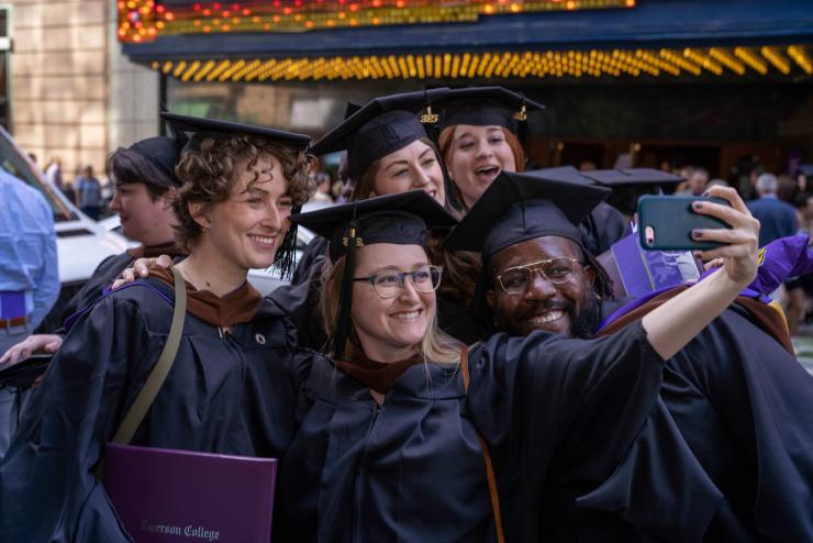 Group of graduates posing for a selfie in caps and gowns