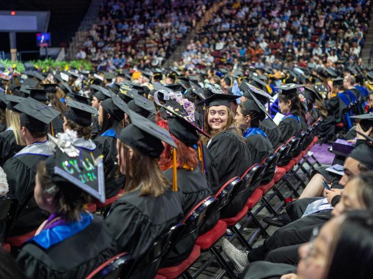 Students in regalia sittings in rows at the graduation ceremony