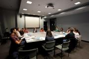 Faculty and students sitting around on a big table in the classroom