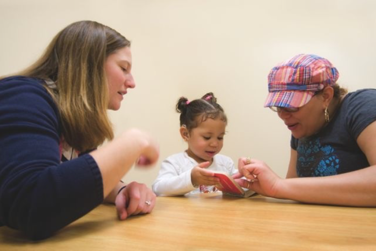 Two adults engaging with a child during therapy