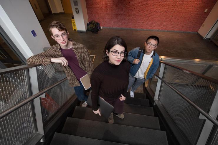 Three students standing on a stairwell
