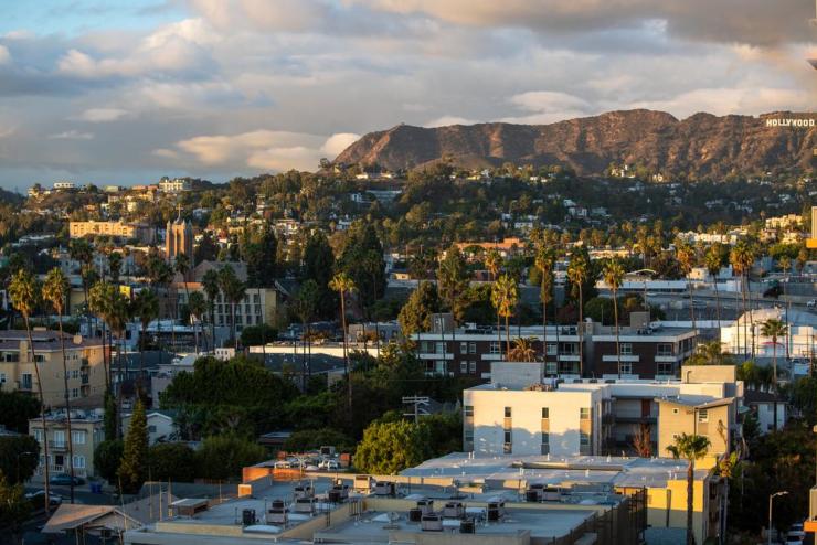 View of the Los Angeles cityscape with mountains and the Hollywood sign in the background