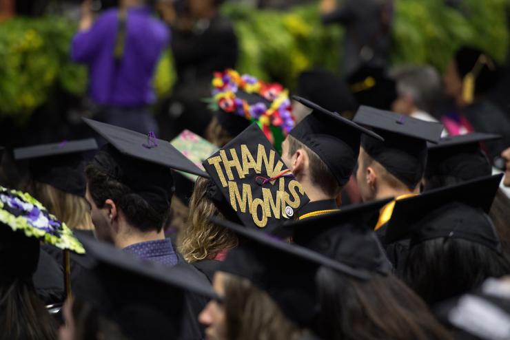 Student at graduation with cap that states thanks mom