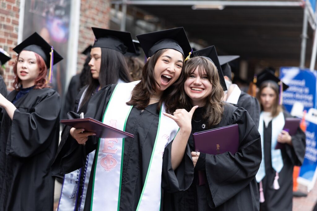 Two alums smile after the ceremony