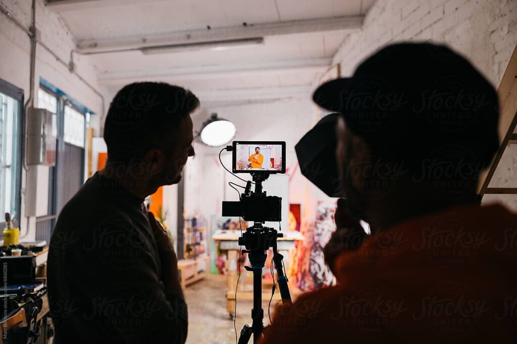 Production crew looking at playback on a monitor while filming a scene.