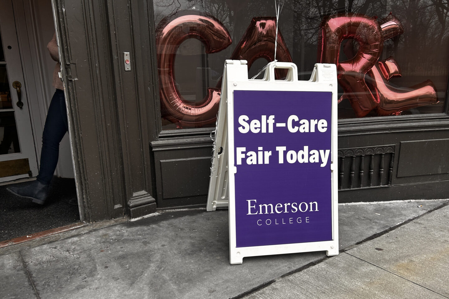 Sandwich signs says: Self-Care Fair Today|||