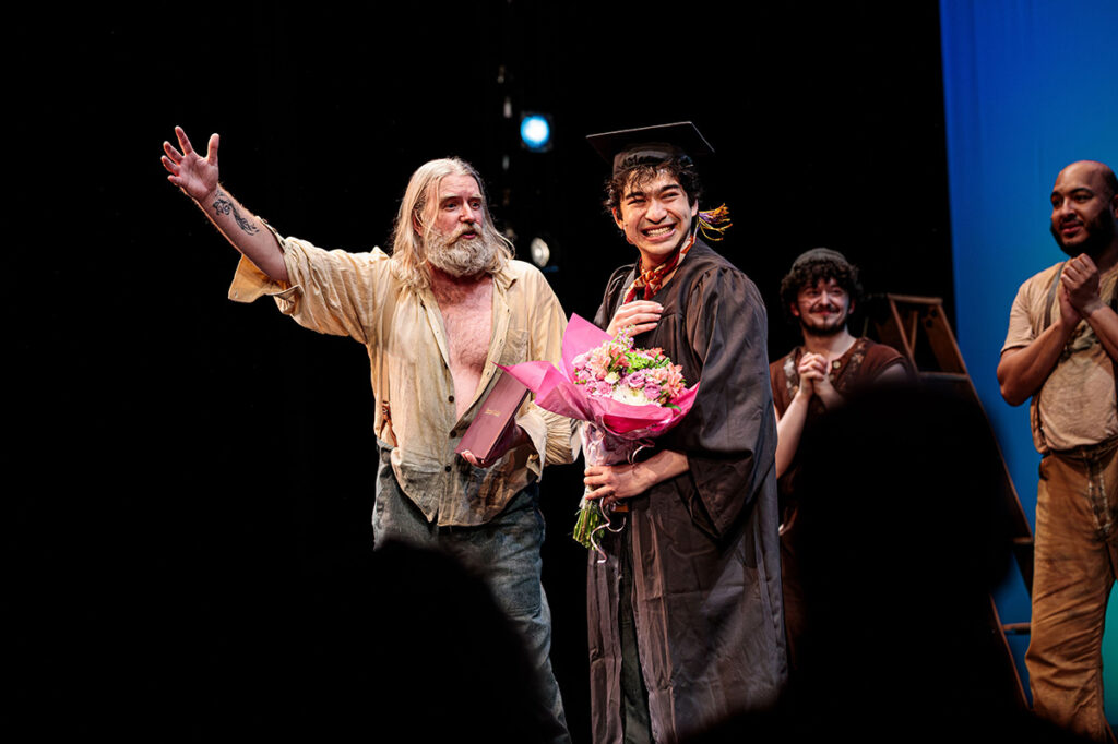 Nicholas Papayoanou reacts with surprise as he receives his Emerson College diploma during the curtain call for Swept Away.||