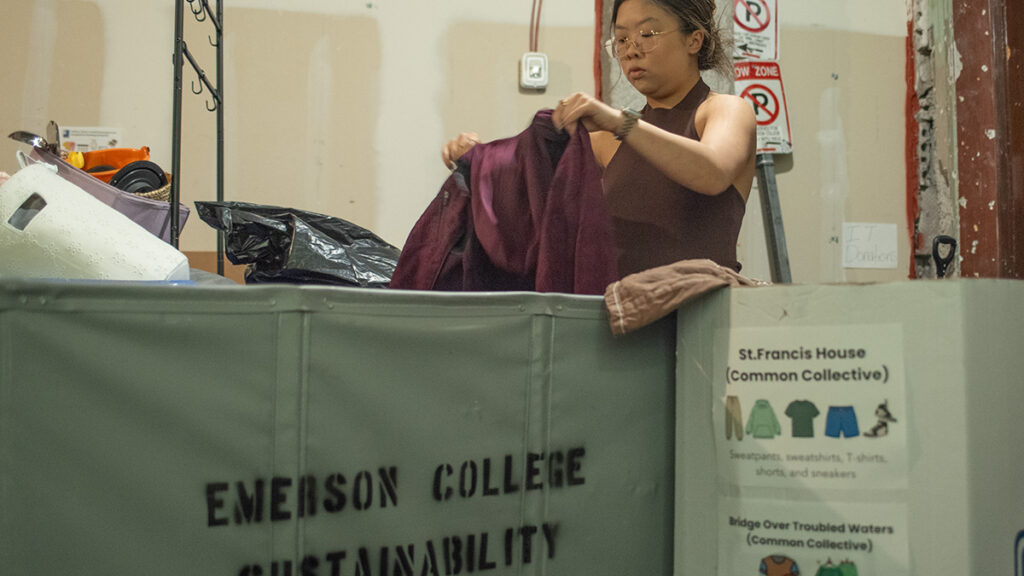 Sophie Lam sorts through donated items with a bin in front of her|